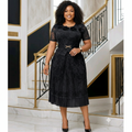 Nigerian woman wearing black lace floral peplum top and pleated midi skirt set