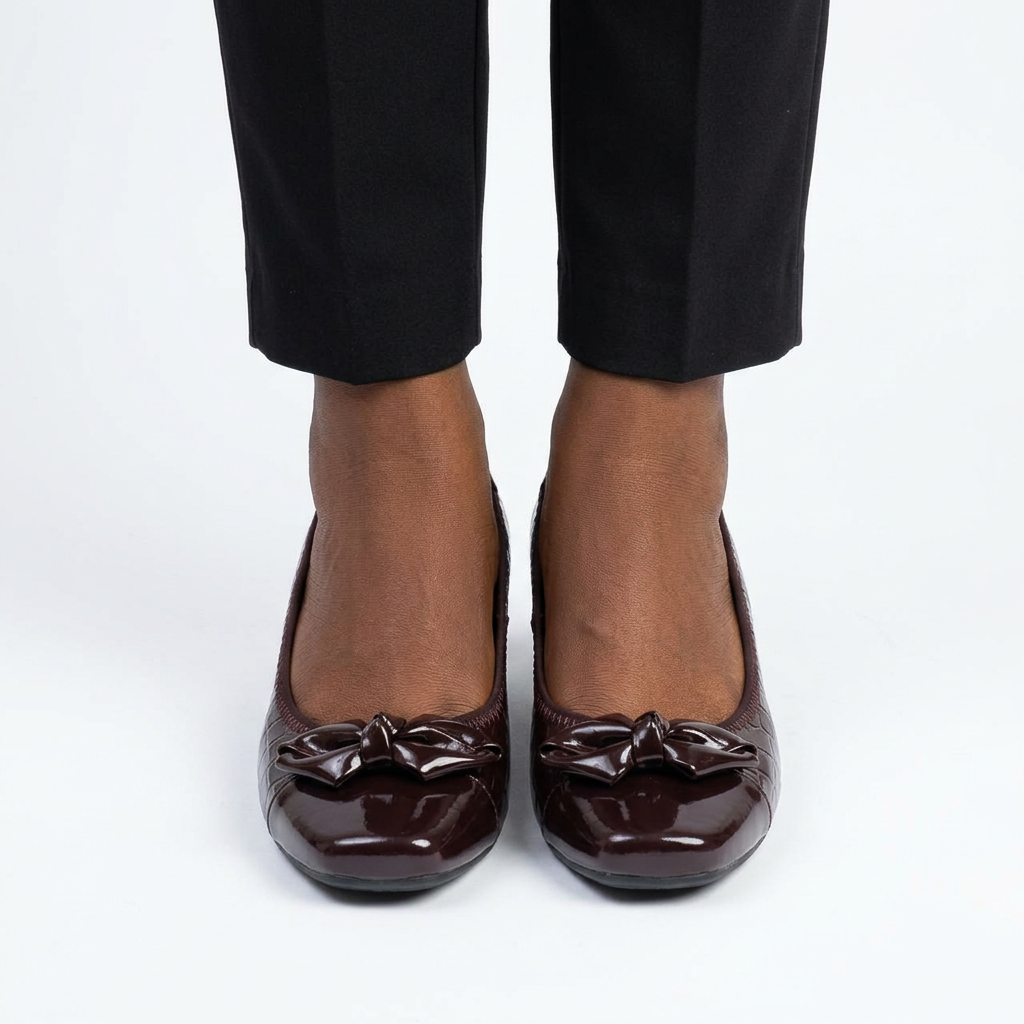 Adult woman wearing burgundy-brown bow wedge shoes with feet together