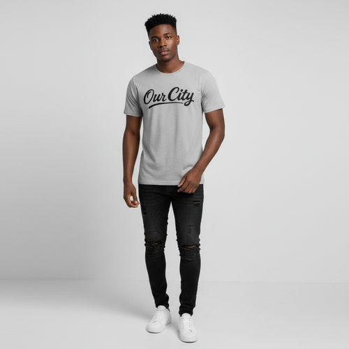 Young Nigerian male wearing light heather grey Our City script graphic crew neck tee
