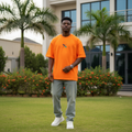 Nigerian male model wearing bright orange abstract geometric graphic tee – front view