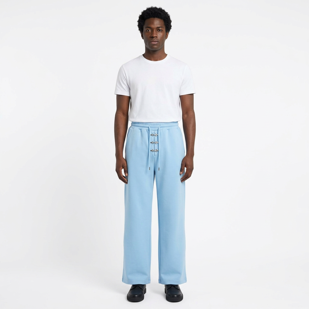 Full-body male model wearing light-blue wide-leg trousers with silver-tone front details