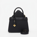 Front view of black textured handbag with gold-tone charm, matching pouch and strap