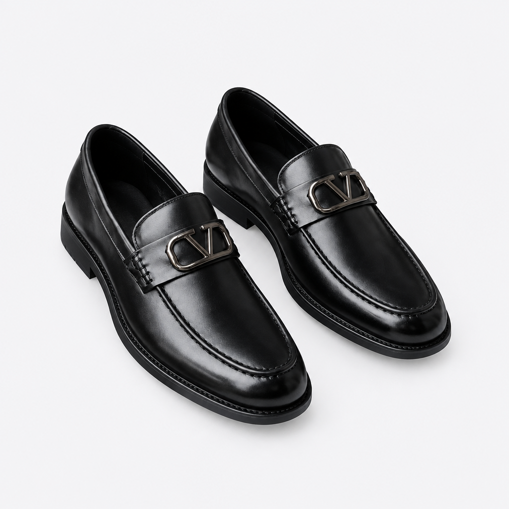 Black men's loafers with polished metal buckle detail shown as a complete pair