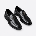 Black men's loafers with polished metal buckle detail shown as a complete pair