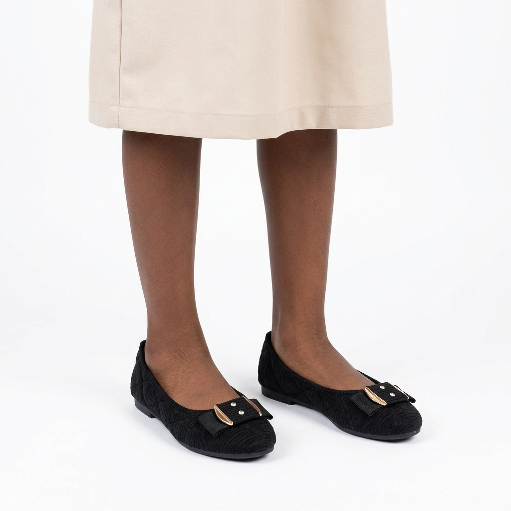 Girl wearing black textured gold-trim ballet flats