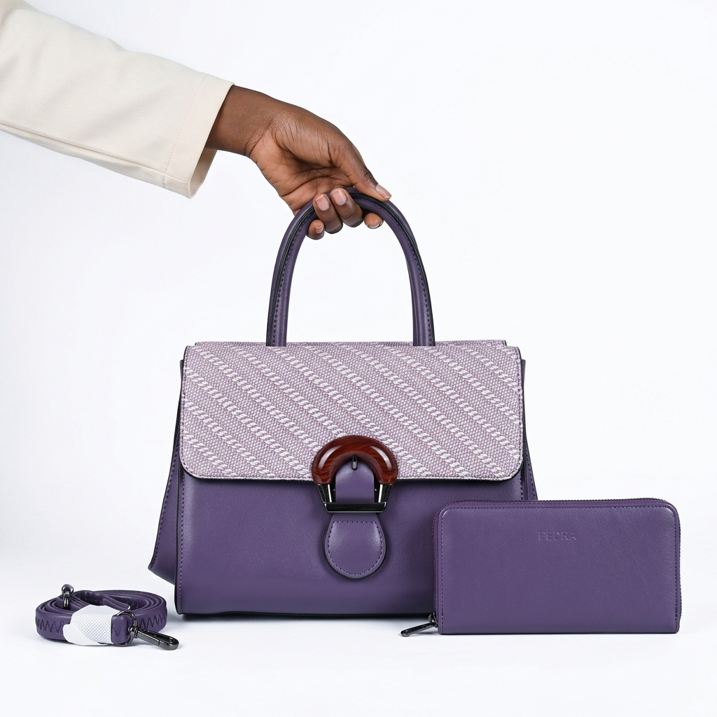 Black adult woman’s hand holding a purple and lilac handbag set on white