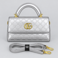 Metallic silver embossed handbag with matching strap