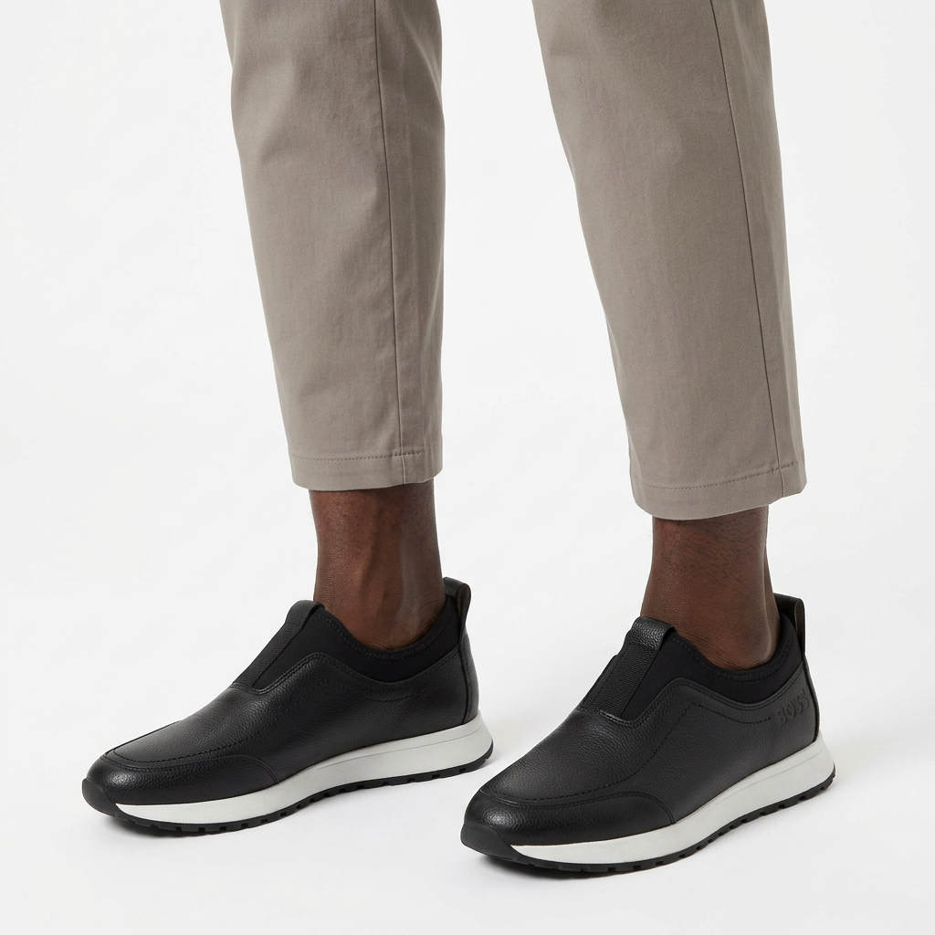 Man wearing black contrast-sole slip-on sneakers with both feet visible