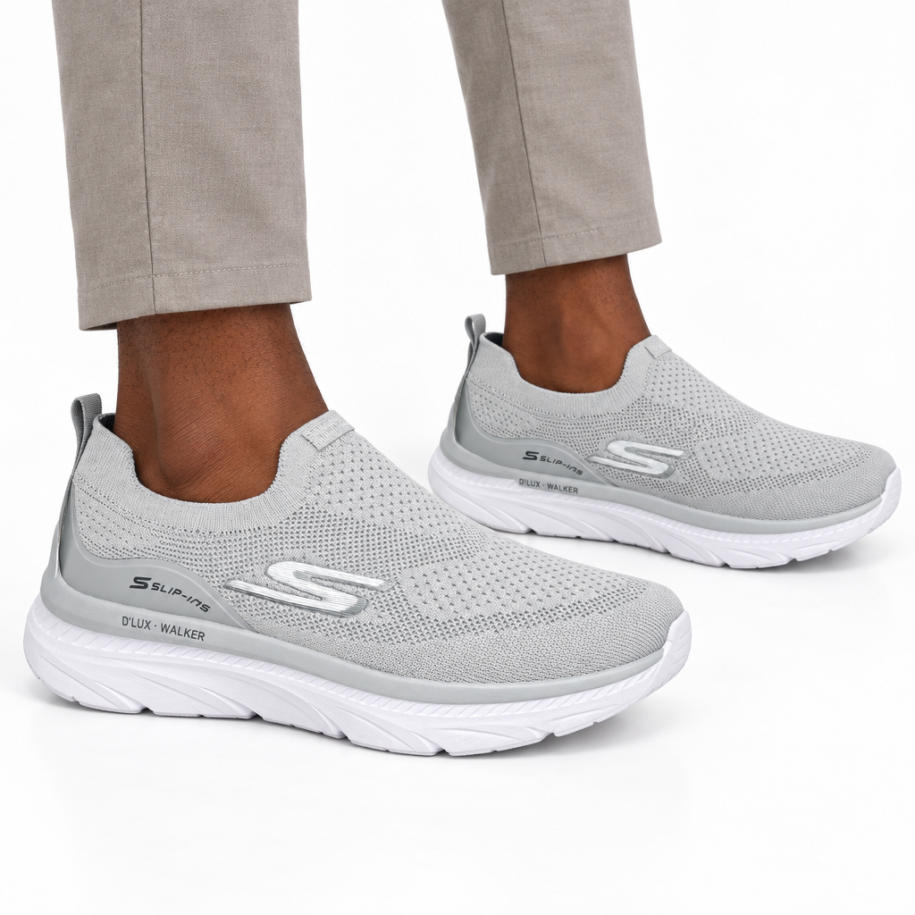 Both silver-grey sneakers worn ankle-down on plain white