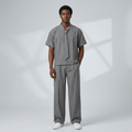 Nigerian male model wearing grey tie-neck shirt and wide-leg trouser set