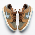 Pair of tan and olive-grey low-top sneakers with pale blue accents on a white background