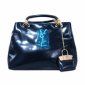 Dark navy glossy handbag with gold-tone hardware and hanging mini-bag charm
