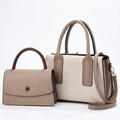 Ivory textured twin-handle handbag with taupe trim beside smaller taupe flap bag