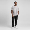Young Nigerian male wearing light grey Reality Next World dual logo crew neck tee