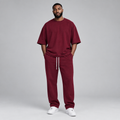 Nigerian male model wearing burgundy oversized t-shirt and jogger tracksuit set