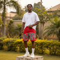 Nigerian male model wearing men's red graffiti tag print clasp hardware denim shorts streetwear style