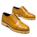 Pair of golden tan medallion cap-toe brogues with light tan lug soles on white