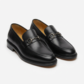 Pair of smooth black metal-bit loafers with beaded sole edges on white