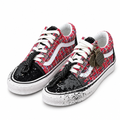 Red woven sneakers with black splatter toes, cord accents and metal charms