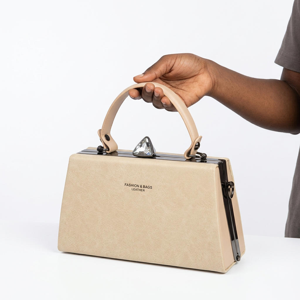 Hand-focused presentation of a cream structured top-handle handbag