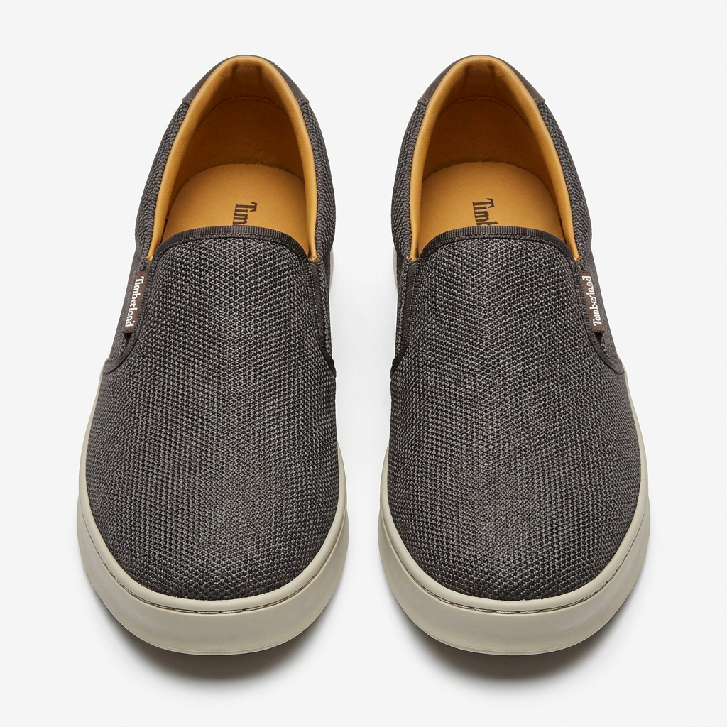 Straight-on charcoal-grey textured slip-on sneakers with light beige soles