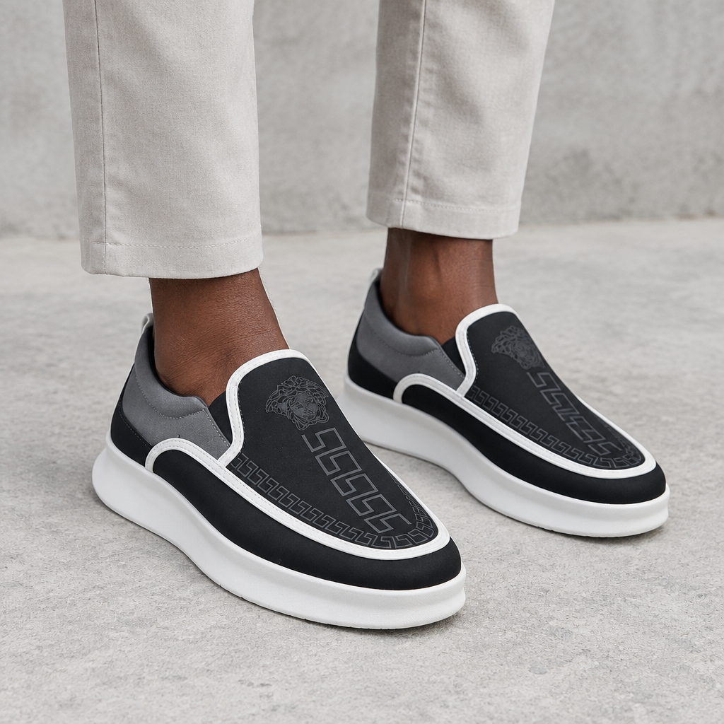 Black-and-grey patterned slip-on loafers worn on both feet