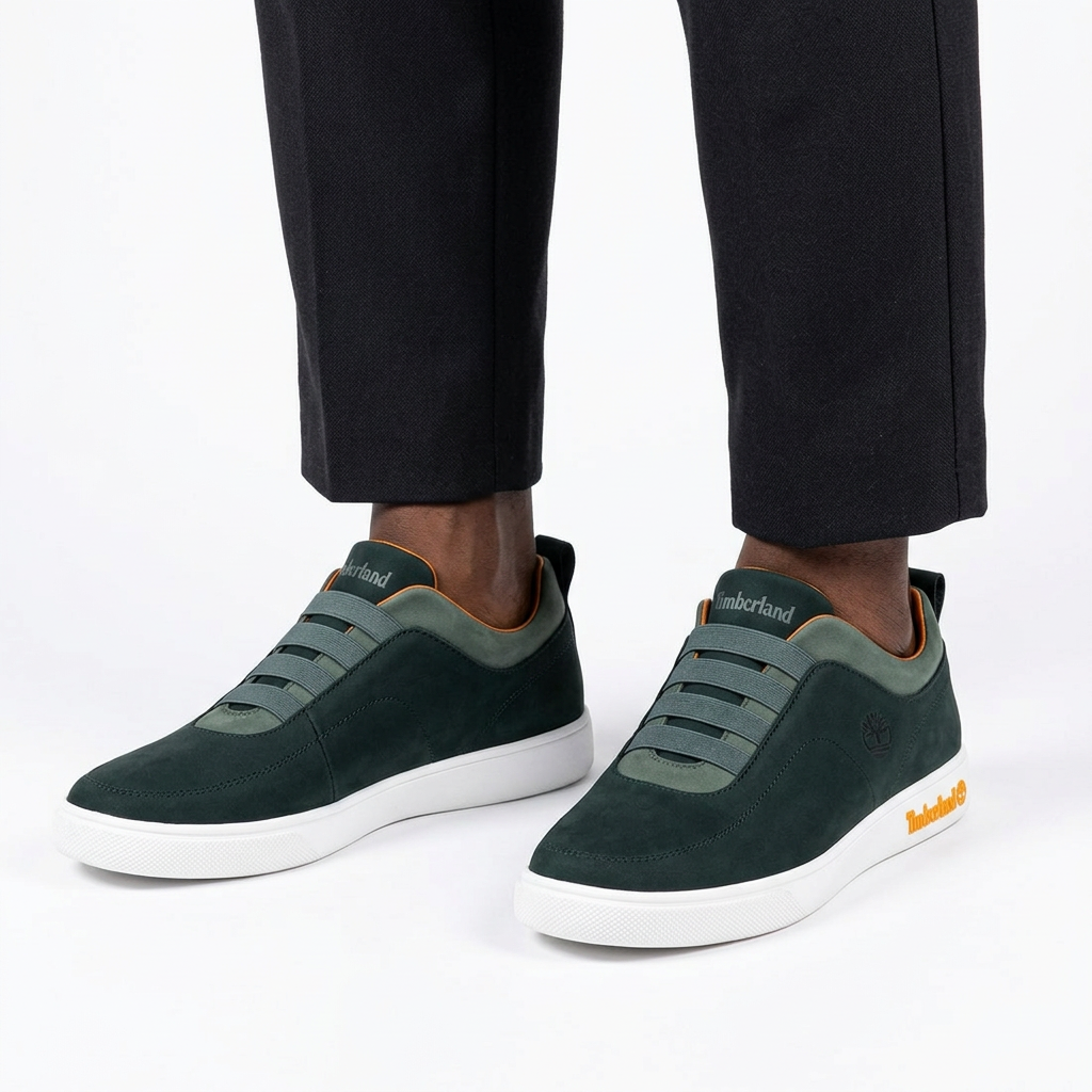 Dark green elastic-band white-sole sneakers properly worn on both feet