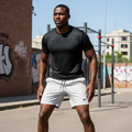 Black Nigerian male model wearing off-white premium sport shorts with black jersey in urban street workout setting