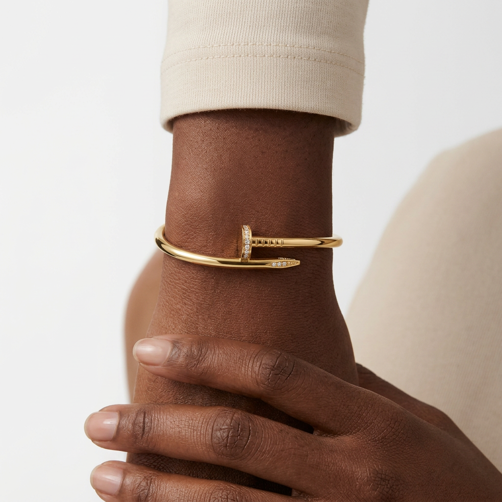 Gold-colour stone-accent nail bracelet worn on a Black adult wrist