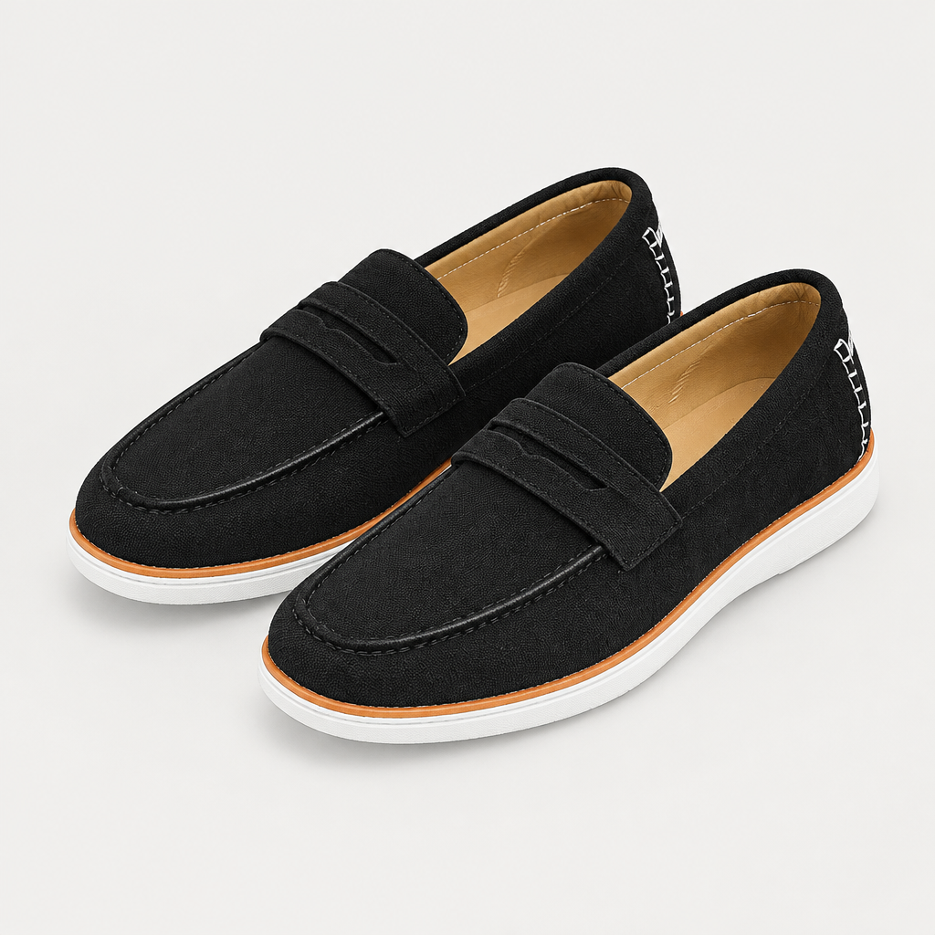 Pair of black suede loafers with contrast tan trim and white soles