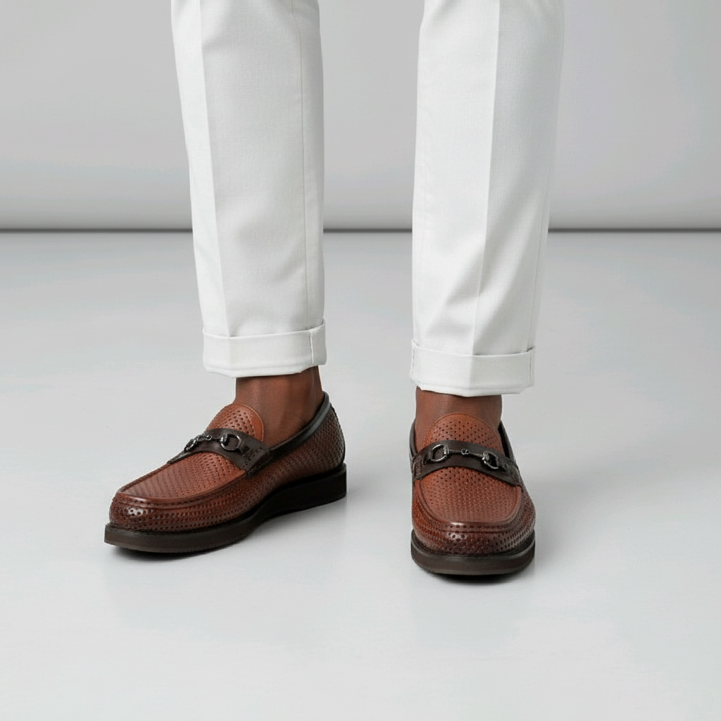 Close-up leg focus of men's brown perforated leather horsebit loafer shoes