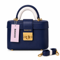 Navy structured box handbag with gold-tone clasp and long strap on white