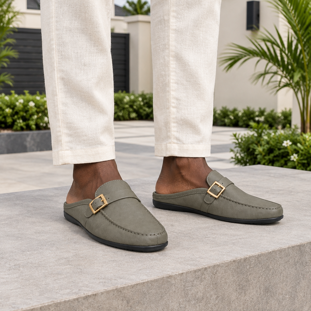 Man wearing grey buckle strap mule slippers with cream linen trousers
