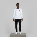 Nigerian male model wearing white long sleeve home football jersey on concrete plinth