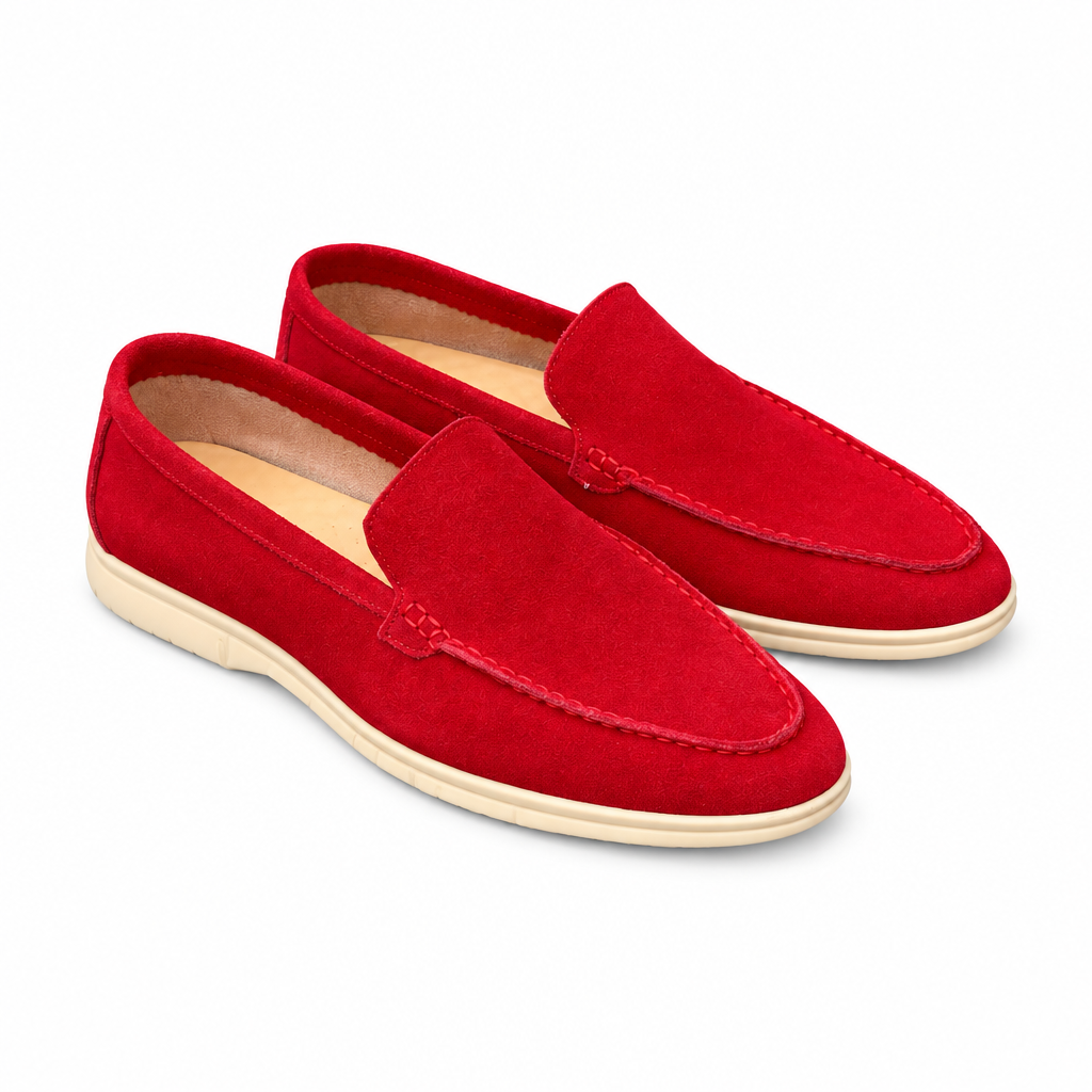 A pair of vivid red suede loafers with cream soles on white
