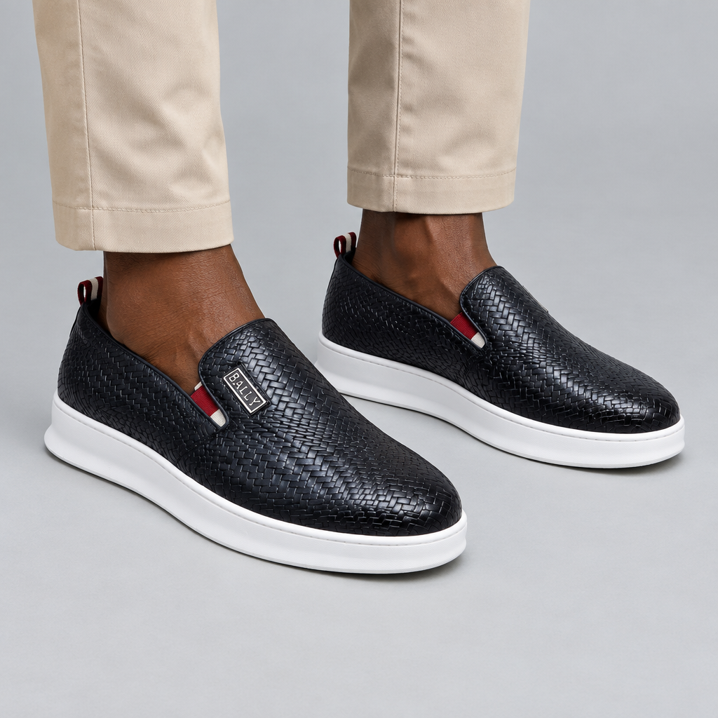 Black woven-texture slip-on shoes worn with beige trousers