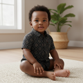Young Nigerian baby boy wearing black geometric diamond print short-sleeve shirt