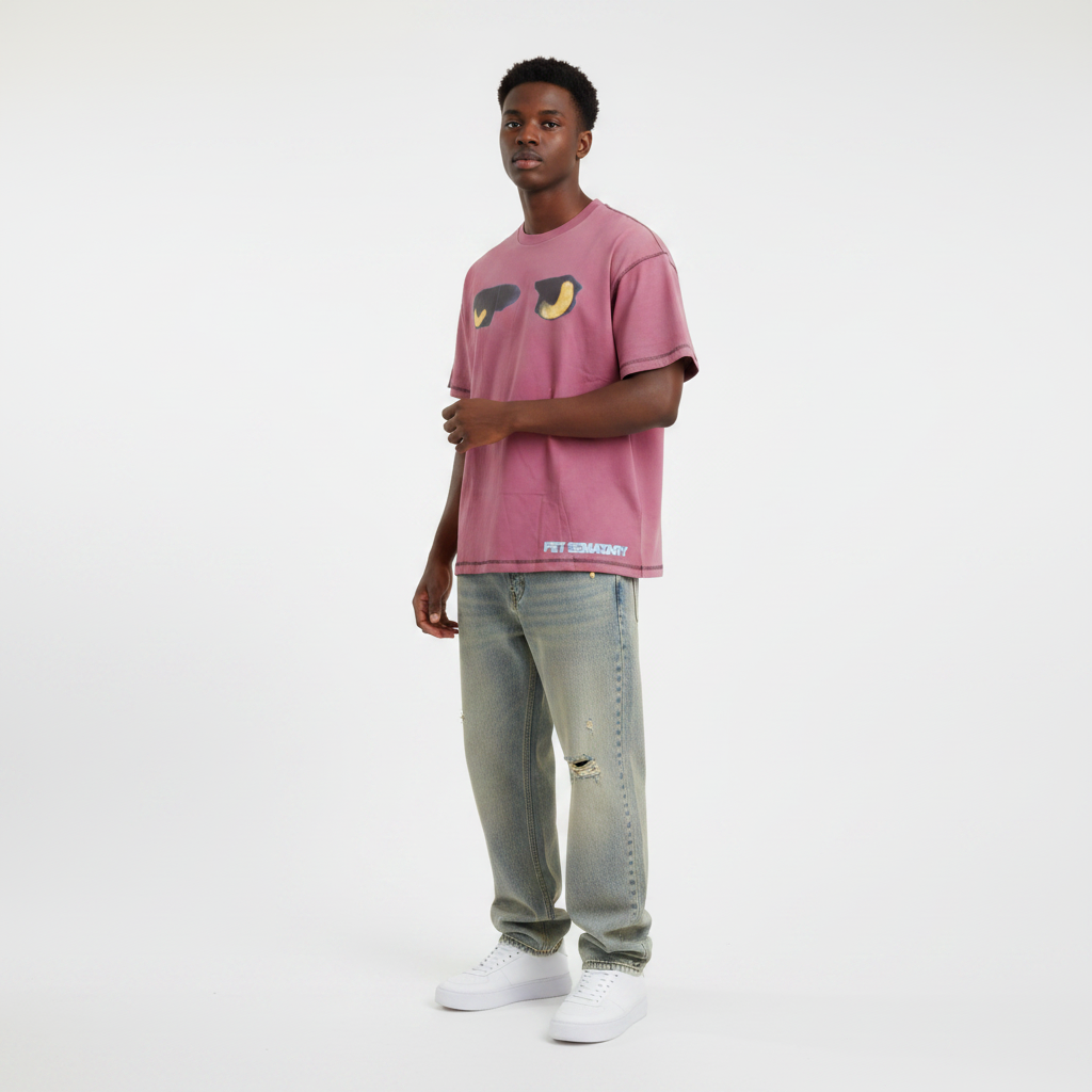 Young Nigerian male wearing dusty rose Pet Sematary cat eyes graphic oversized tee