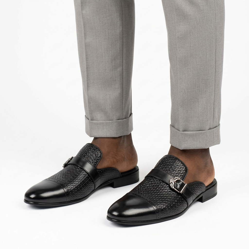 Men’s black buckle mule shoes worn with tailored trousers