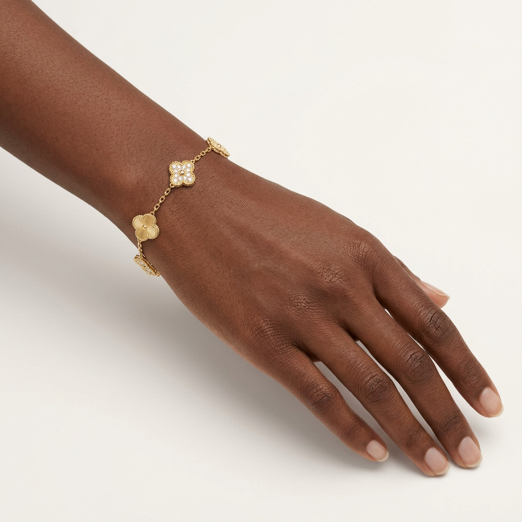 Gold-tone stone-detail clover bracelet worn on a wrist