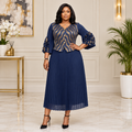 Adult Black woman wearing a navy gold patterned pleated dress