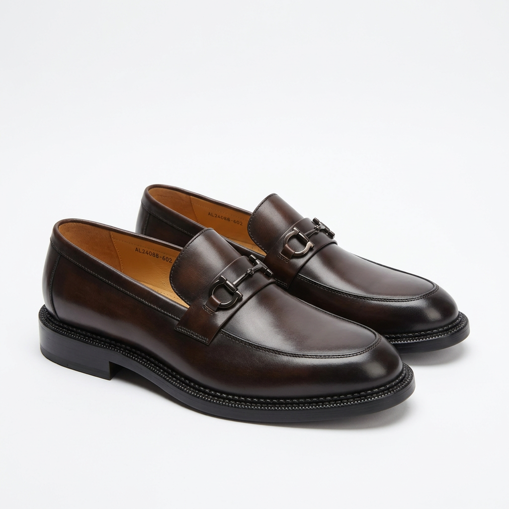 Pair of polished espresso-brown bit loafers on white