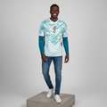 Nigerian male model wearing white teal wave long sleeve football jersey on concrete plinth