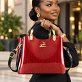 Nigerian woman holding crimson structured handbag with black handles and gold fittings