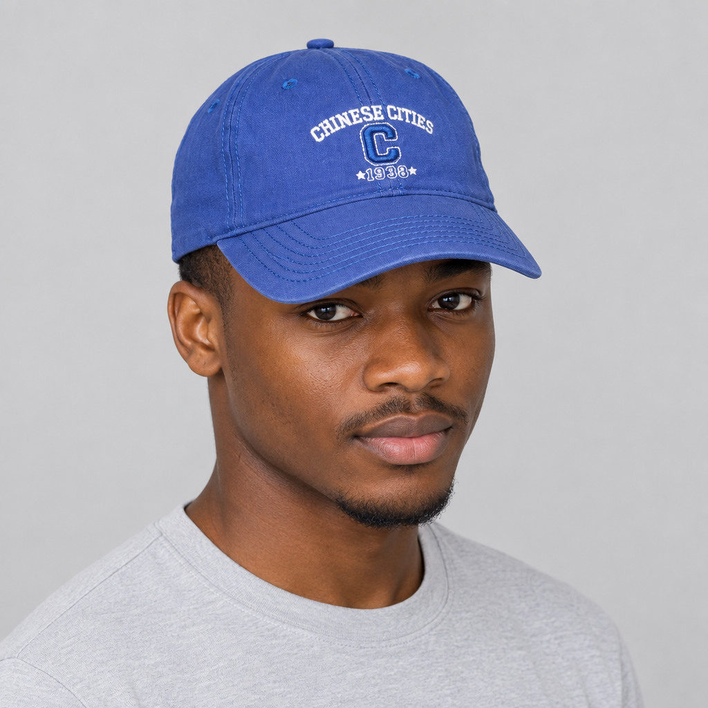 Nigerian man wearing blue embroidered cap against a plain studio background