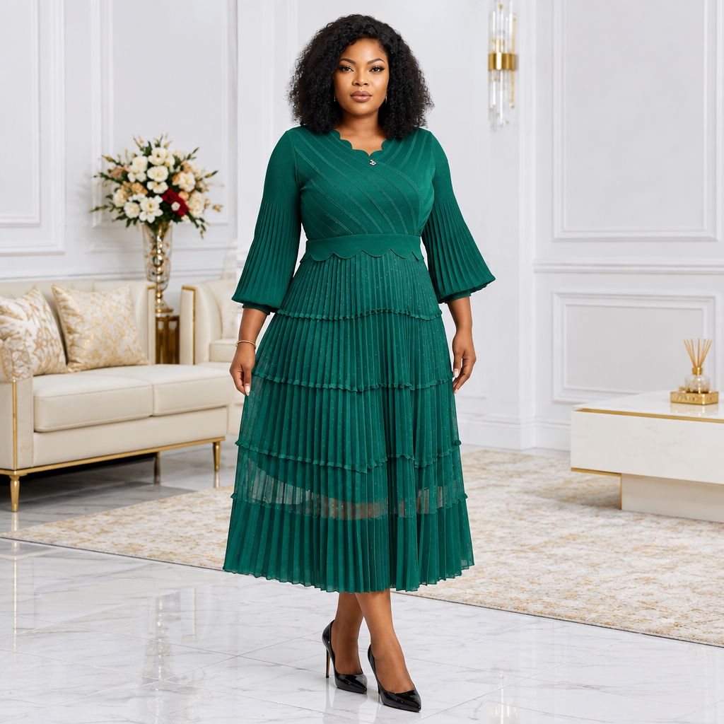 Black Nigerian woman wearing emerald green tiered pleated dress