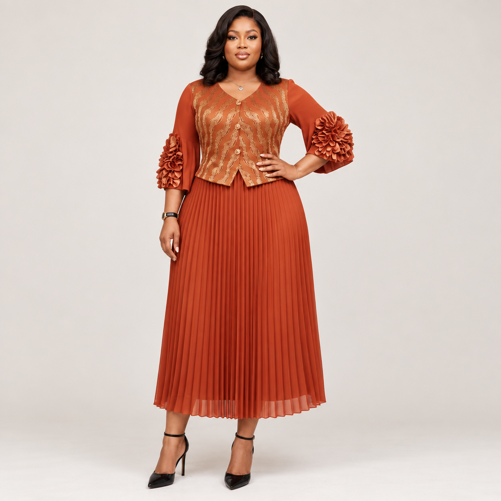 Black Nigerian model wearing a rust-orange pleated gown with a patterned bodice and floral cuff accents