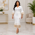 Adult Black woman wearing a white gold-trimmed bell sleeve dress