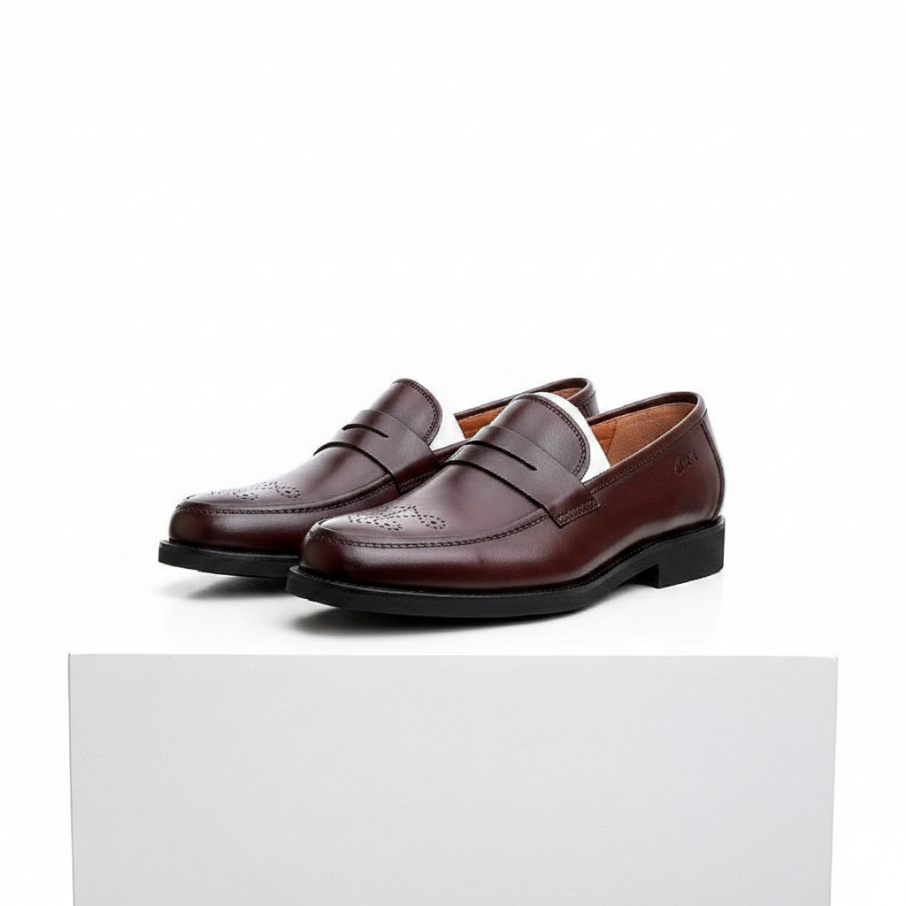 Men's brown leather brogue toe penny loafer shoes pair on white platform