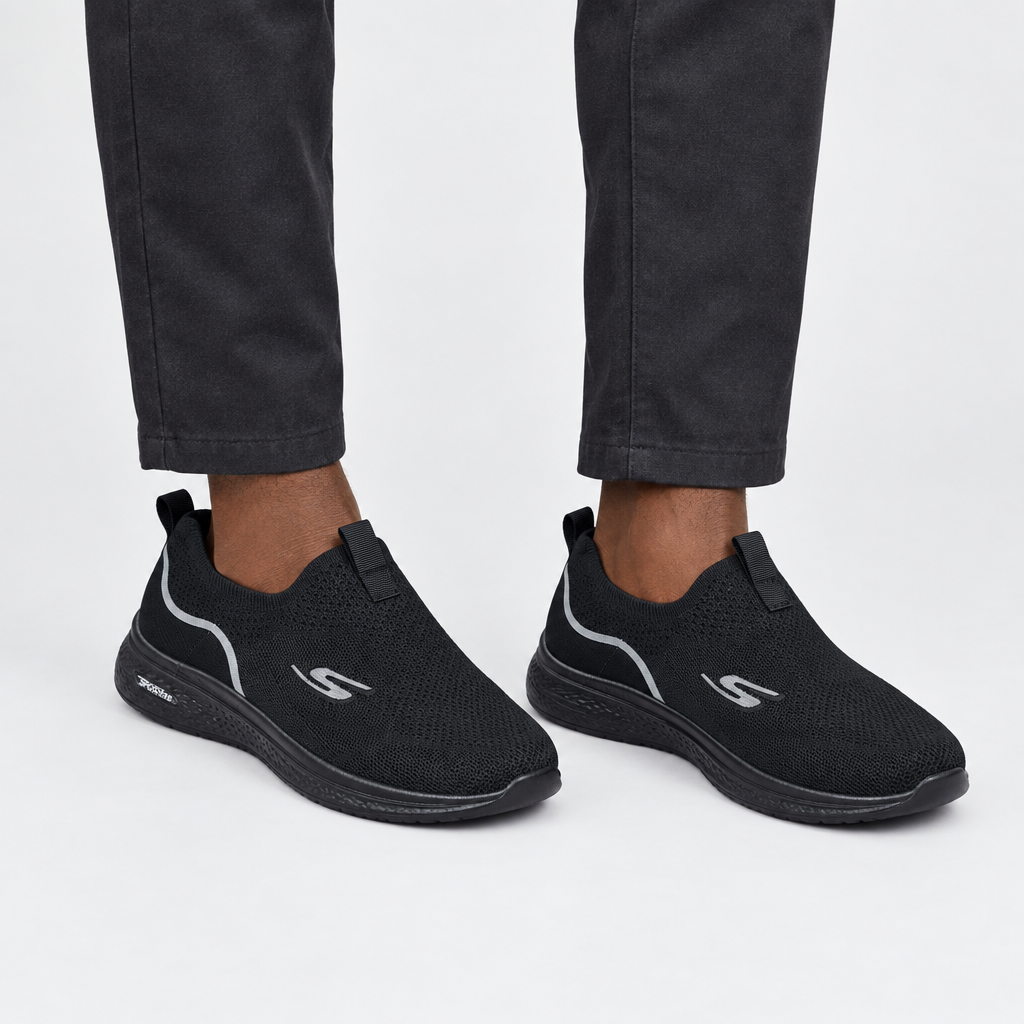 Leg-focused model wearing black knit slip-on sneakers